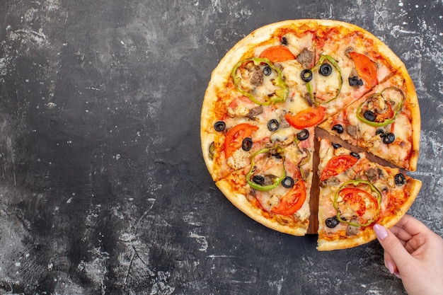 Vista dall'alto deliziosa pizza al formaggio affettata e servita su sfondo grigio