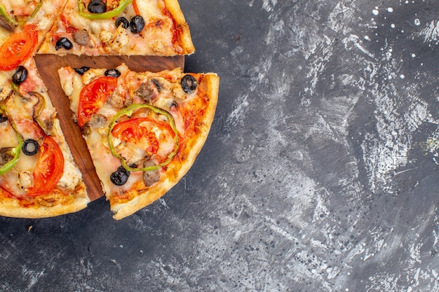 Vista dall'alto deliziosa pizza al formaggio affettata e servita su una superficie grigia