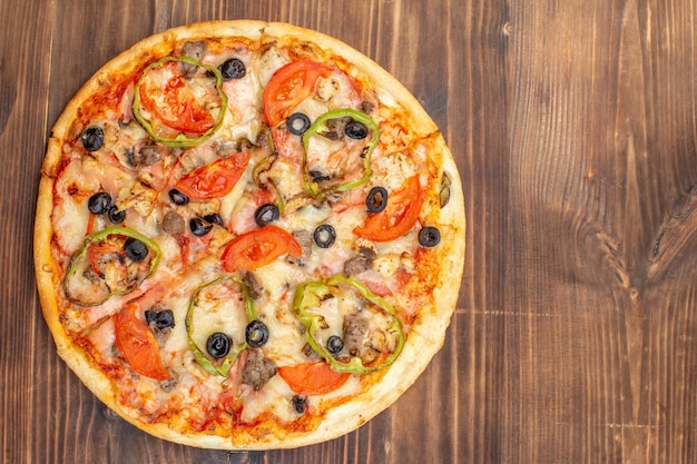 Vista dall'alto deliziosa pizza al formaggio su una superficie di legno marrone