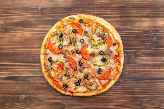 Vista dall'alto deliziosa pizza al formaggio su una superficie di legno marrone