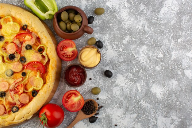 Vista dall'alto deliziosa pizza di formaggio con olive salsicce e pomodori rossi su sfondo grigio fast-food pasta italiana