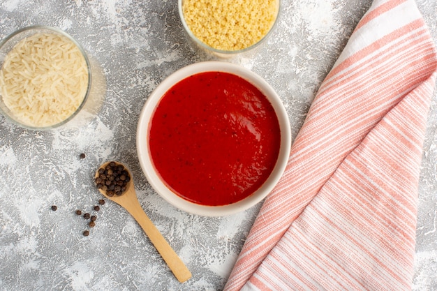 Vista dall'alto deliziosa salsa di pomodoro all'interno del piatto bianco sul cibo vegetale cena pasto minestra scrivania grigia