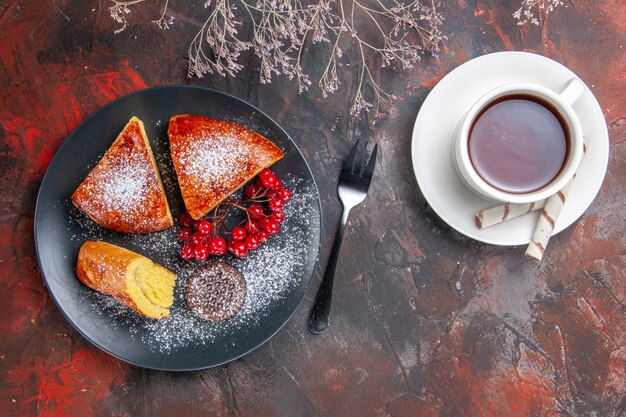 Vista dall'alto deliziosa torta a fette con bacche rosse sul tavolo scuro torta torta dolce tè