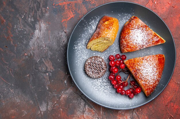 Vista dall'alto deliziosa torta a fette con bacche rosse sulla torta dolce torta tavolo scuro