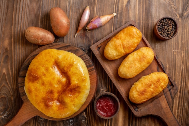 Vista dall'alto deliziosa torta al forno con purè di patate all'interno e hotcakes su una scrivania in legno torta hotcake torta al forno pasta pasto