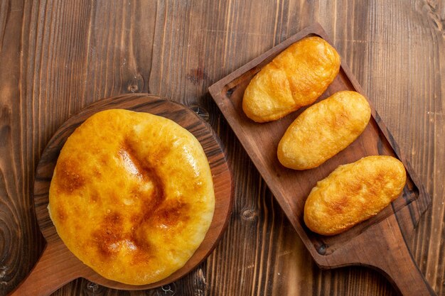 Vista dall'alto deliziosa torta al forno con purè di patate all'interno e hotcakes su una scrivania in legno torta hotcake torta al forno pasta pasto