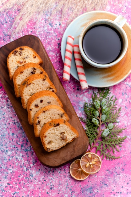 Vista dall'alto deliziosa torta all'uvetta affettata torta sulla superficie rosa cuocere i biscotti al biscotto dolce zucchero torta