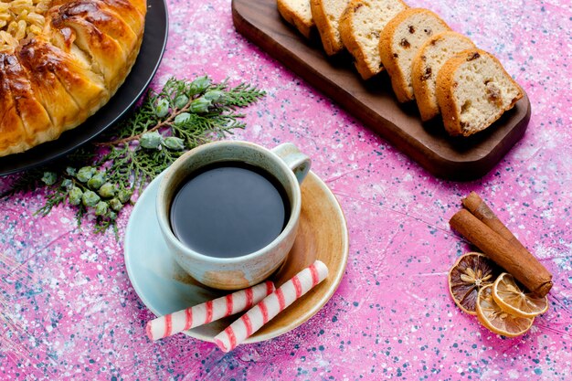 Vista dall'alto deliziosa torta all'uvetta con una tazza di caffè sulla scrivania rosa cuocere la torta di zucchero biscotto dolce colore del biscotto