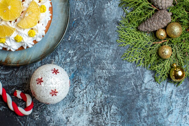 Vista dall'alto deliziosa torta alla crema con frutta a fette e giocattoli