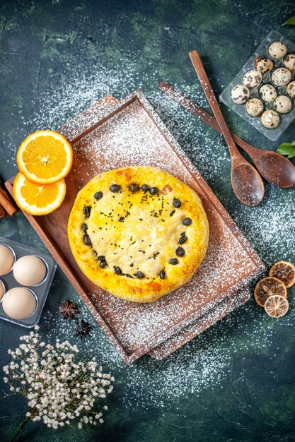 Vista dall'alto deliziosa torta con frutta su superficie blu scuro