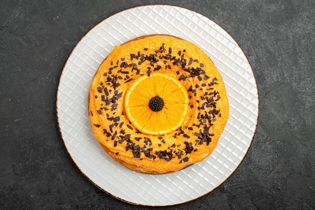 Vista dall'alto deliziosa torta con gocce di cioccolato e fette d'arancia sulla superficie scura torta da dessert torta da tè biscotto alla frutta