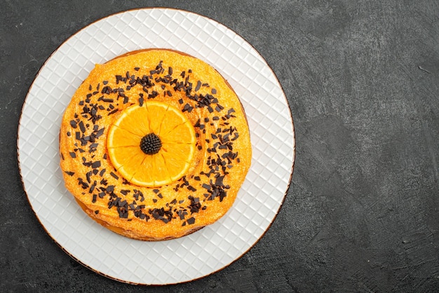 Vista dall'alto deliziosa torta con gocce di cioccolato e fette d'arancia sulla superficie scura torta da dessert torta da tè biscotto alla frutta