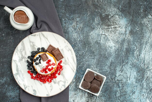 Vista dall'alto deliziosa torta cremosa con cioccolato e uvetta su sfondo chiaro-scuro