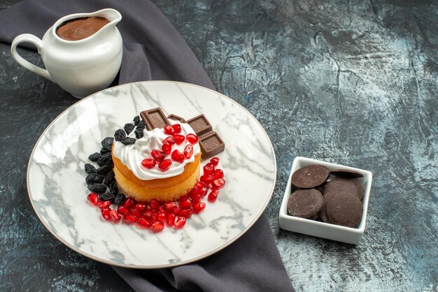 Vista dall'alto deliziosa torta cremosa con cioccolato e uvetta sul pavimento chiaro-scuro