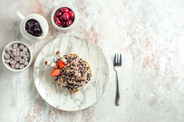 Vista dall'alto deliziosa torta cremosa con fragole su superficie bianca crema di compleanno torta di tè dolce biscotto