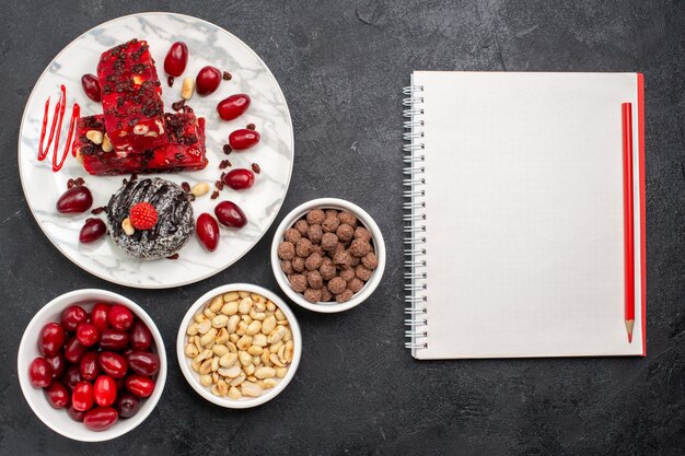 Vista dall'alto deliziosa torta di fette di torta fruttata con noci e cornioli su uno spazio grigio