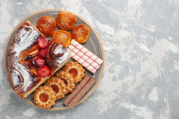 Vista dall'alto deliziosa torta di fragole con biscotti e torte sulla superficie bianca biscotto torta di zucchero torta dolce biscotto