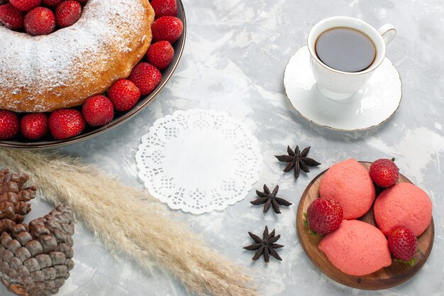 Vista dall'alto deliziosa torta di fragole con tè su bianco chiaro