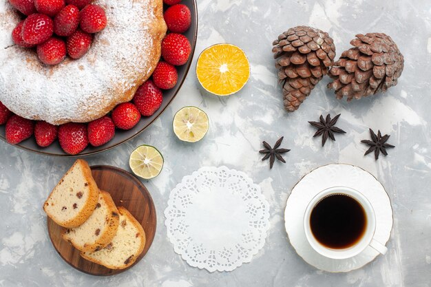 Vista dall'alto deliziosa torta di fragole con una tazza di tè su bianco