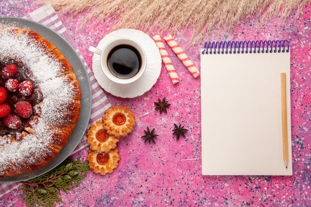 Vista dall'alto deliziosa torta di fragole zucchero in polvere con una tazza di tè e biscotti sullo sfondo rosa chiaro torta biscotti dolci tè