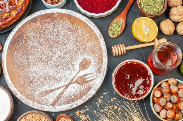 Vista dall'alto deliziosa torta di frutta con noci miele e marmellata sul tavolo scuro