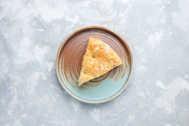 Vista dall'alto deliziosa torta di mele affettata all'interno della piastra sulla scrivania bianca torta torta di zucchero dolce cuocere il biscotto