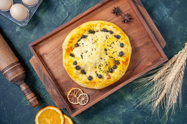 Vista dall'alto deliziosa torta dolce con frutti di bosco su superficie blu scuro