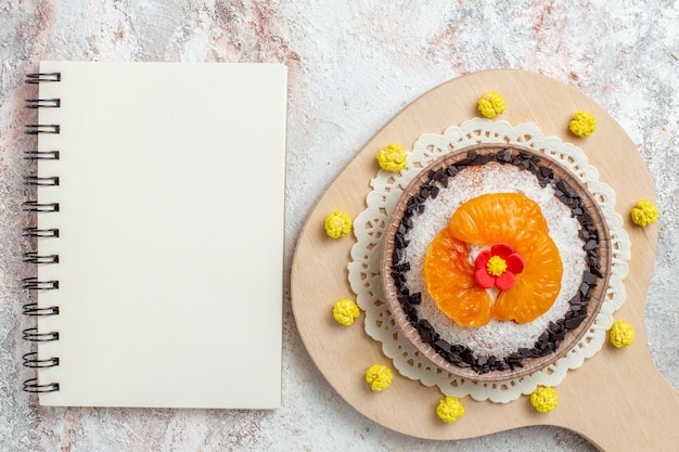 Vista dall'alto deliziosa torta dolce con mandarini a fette su sfondo bianco torta alla crema di biscotti alla frutta dolce