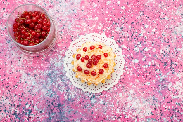 Vista dall'alto deliziosa torta rotonda con mirtilli rossi freschi in cima e separatamente sullo zucchero da scrivania viola