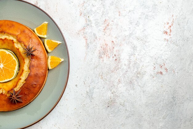 Vista dall'alto deliziosa torta rotonda delizioso dessert per il tè con fette d'arancia su sfondo bianco torta di frutta torta biscotto tè dolce dessert