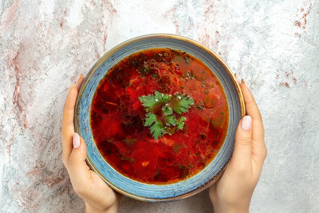 Vista dall'alto deliziosa zuppa di barbabietola ucraina famosa borsch con carne all'interno del piatto su spazio bianco