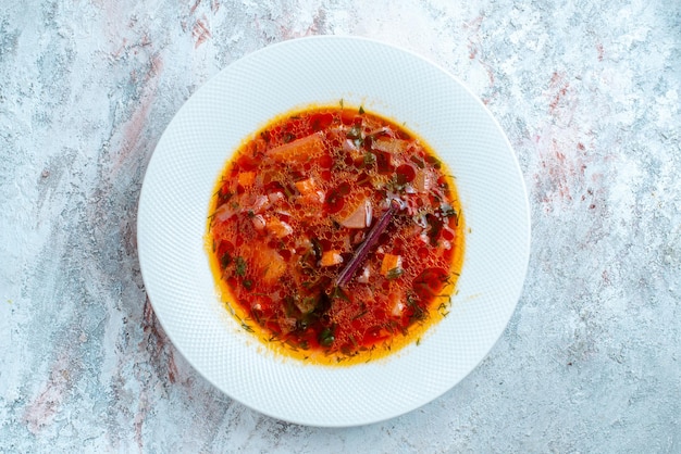 Vista dall'alto deliziosa zuppa di barbabietola ucraina famosa borsch con carne all'interno del piatto su uno spazio bianco chiaro