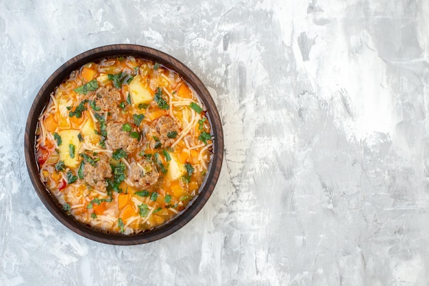 Vista dall'alto deliziosa zuppa di carne all'interno del piatto su sfondo bianco zuppa di cibo cena calda piatto di carne colore verdura spazio libero