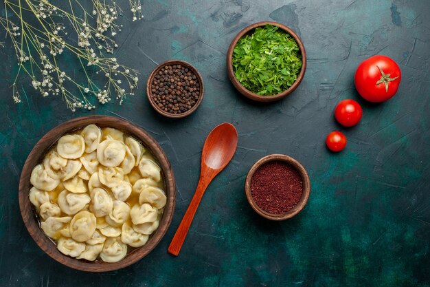 Vista dall'alto deliziosa zuppa di gnocchi con condimenti sulla pasta di zuppa di verdure di carne di cibo da scrivania verde scuro