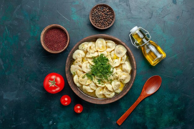 Vista dall'alto deliziosa zuppa di gnocchi con diversi condimenti su una zuppa di pasta alimentare vegetale di carne da scrivania verde scuro