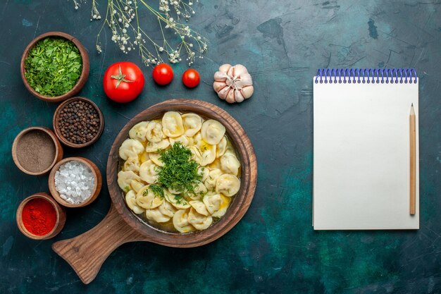 Vista dall'alto deliziosa zuppa di gnocchi con diversi condimenti su zuppa di pasta di verdure superficie verde