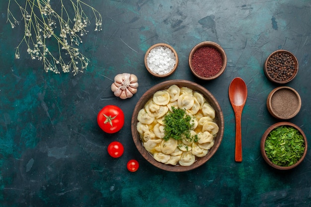 Vista dall'alto deliziosa zuppa di gnocchi con diversi condimenti sulla superficie verde zuppa di carne pasta vegetale cibo