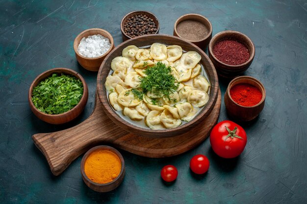 Vista dall'alto deliziosa zuppa di gnocchi con diversi condimenti sulla zuppa di pasta vegetale di carne di cibo da scrivania verde