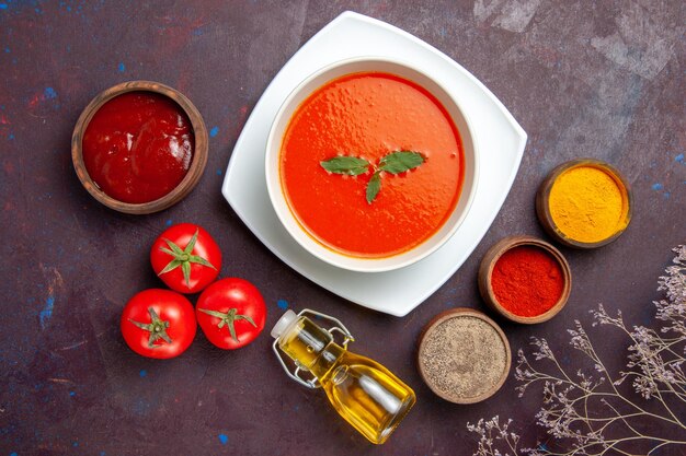 Vista dall'alto deliziosa zuppa di pomodoro con condimenti sullo sfondo scuro salsa di pomodoro zuppa di farina colorata