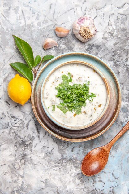 Vista dall'alto deliziosa zuppa di yogurt dovga con verdure su piatto da tavola bianco per zuppa di latte