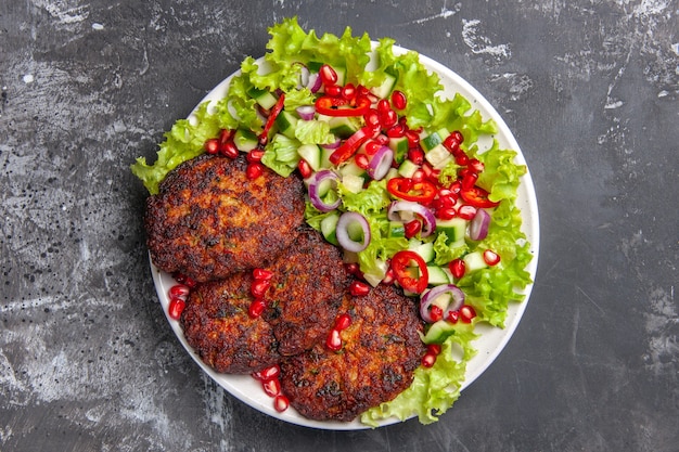 Vista dall'alto deliziose cotolette di carne con insalata fresca