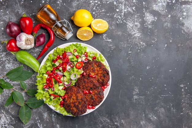 Vista dall'alto deliziose cotolette di carne con insalata fresca