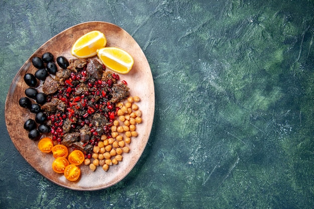 vista dall'alto deliziose fette di carne fritte con fagioli uva e fette di limone all'interno del piatto, piatto di carne frutta cibo