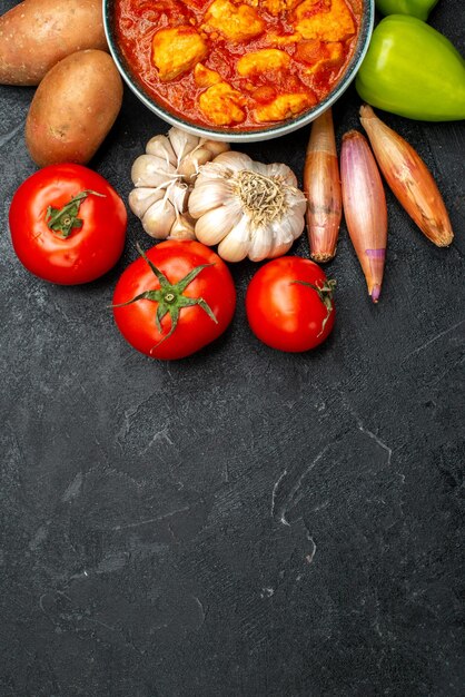 Vista dall'alto deliziose fette di pollo con salsa di pomodoro e verdure su sfondo grigio scuro piatto di salsa carne di pollo pomodoro