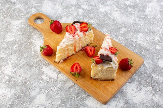 Vista dall'alto deliziose fette di torta con crema al cioccolato e fragola sullo sfondo chiaro torta biscotto tè dolce