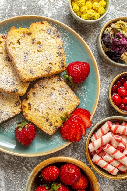 Vista dall'alto deliziose fette di torta con frutta sulla torta di frutta torta dolce superficie leggera