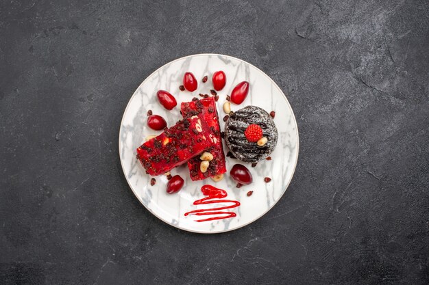 Vista dall'alto deliziose fette di torta con torta al cioccolato su uno spazio grigio scuro