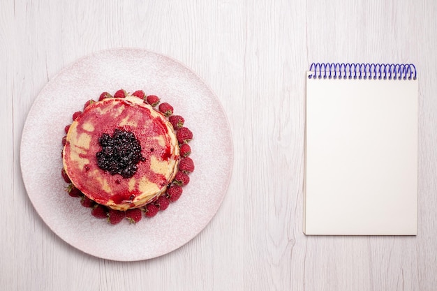 Vista dall'alto deliziose frittelle con fragole e gelatina su sfondo bianco frutta torta torta biscotto dolce bacca