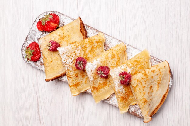 Vista dall'alto deliziose frittelle con frutta su sfondo bianco torta dolce dessert frutta tè pancake