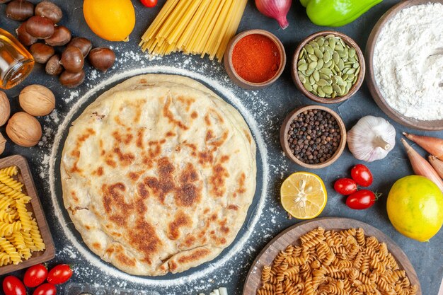 Vista dall'alto deliziose frittelle con ingredienti diversi condimenti e pasta su sfondo scuro colore cibo pasto piatto pane panino